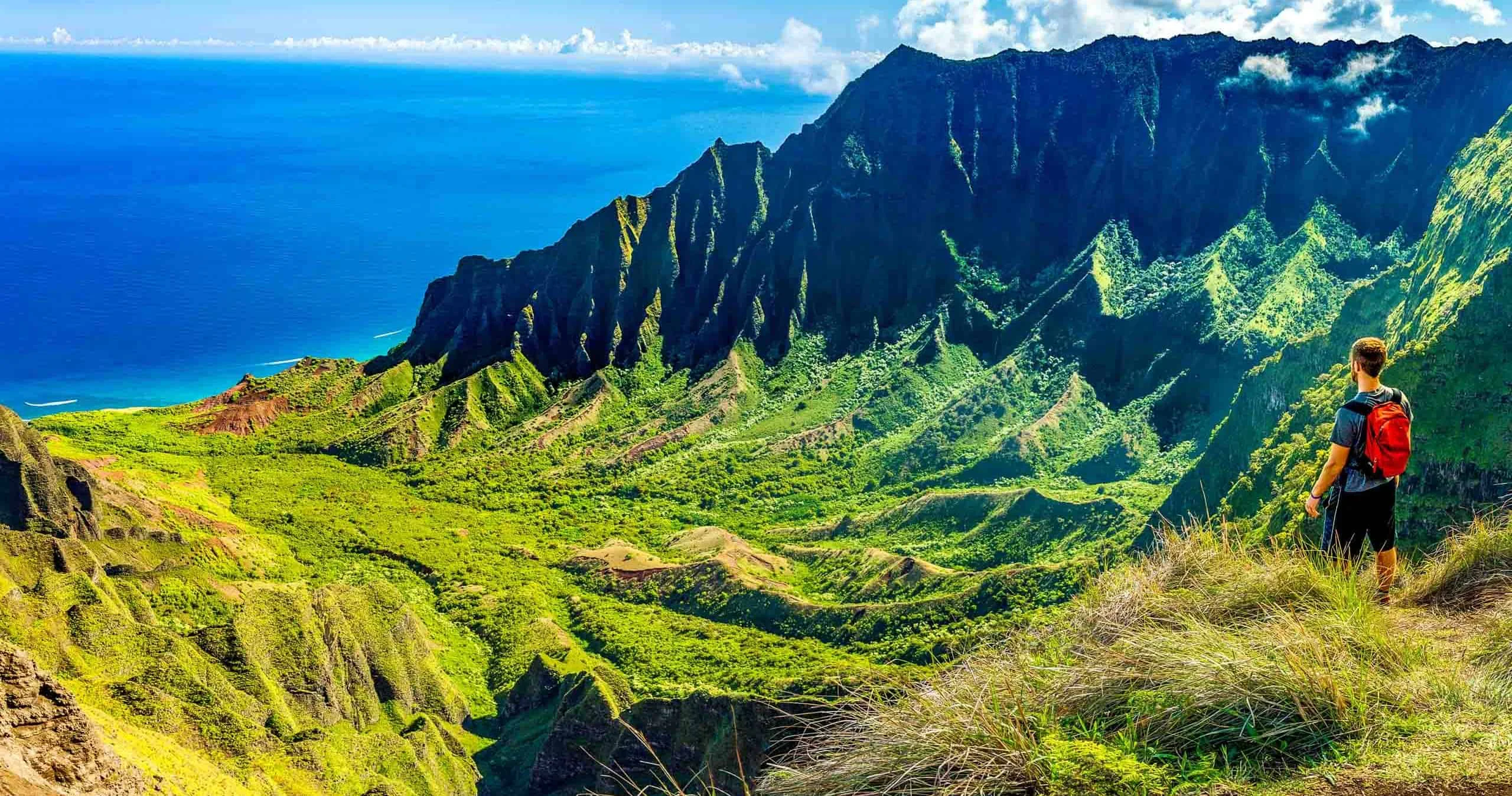 Helicopter flying over green mountain ridges and waterfalls in Hawaii