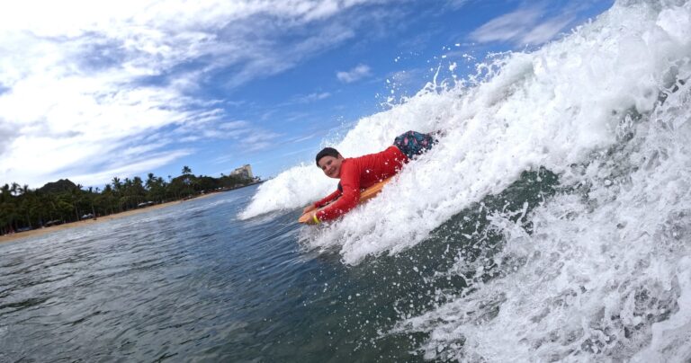 Bodyboarder riding a breaking wave in Waikiki, Oahu