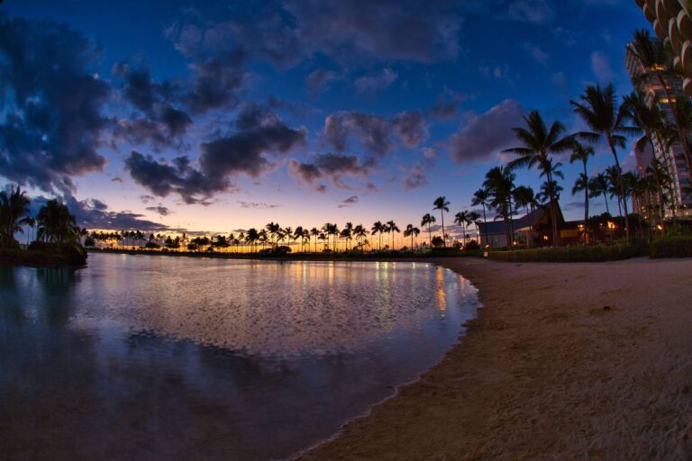 Sunset over Waikiki Beach in Honolulu, Oahu, Hawaii, with surfers in the water