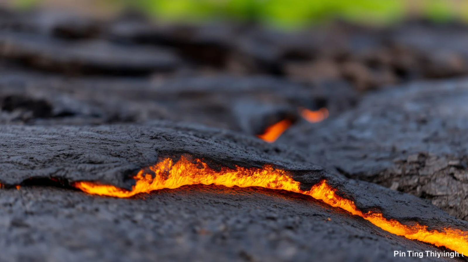 Molten lava flowing in bright orange channels across dark cooled volcanic rock